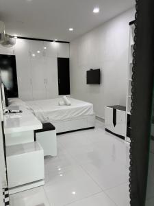 a white room with a bed and a mirror at Muong Thanh Oceanfront Retreat apartment in Nha Trang