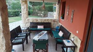 an outdoor patio with chairs and tables and a window at Villa Mariellie in Nea Peramos +50 photos