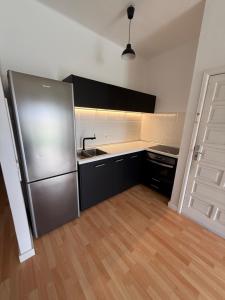 een keuken met een roestvrijstalen koelkast en een houten vloer bij bonito y acogedor apartamento in Famara