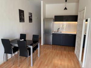 een keuken met een tafel, stoelen en een koelkast bij bonito y acogedor apartamento in Famara +6 foto's