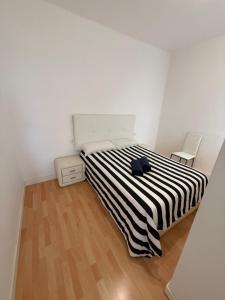 een slaapkamer met een zwart-wit gestreept bed bij bonito y acogedor apartamento in Famara
