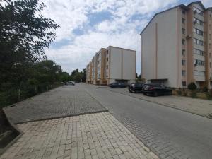 an empty street with cars parked next to buildings at NOI-Apartment in Căuşeni