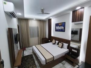 a hotel room with a bed and a tv at Hotel Muskan in Mathura