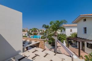 een balkon met uitzicht op het zwembad van een resort bij Villa Enaria Serene 3Bdr Retreat in Ayia Thekla in Ayia Napa