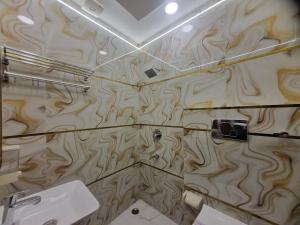 a bathroom with wooden walls and a sink and a mirror at Hotel Muskan in Mathura