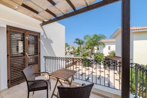 een balkon met een tafel en stoelen en uitzicht bij Villa Enaria Serene 3Bdr Retreat in Ayia Thekla in Ayia Napa