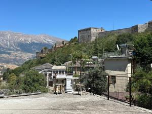 ジロカストラにあるAntAjlaの山を背景にした建物