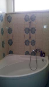 a bath tub in a bathroom with blue flowers on the wall at Casa Vacanze Corso Umberto in Giardini Naxos