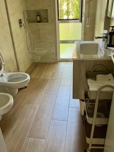 a bathroom with two sinks and a toilet and a shower at San Pietro Premium Meliá Garden Apartment in Lalzit Bay +39 photos
