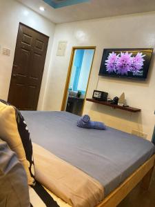 a bedroom with a bed and a tv on the wall at Coastal Whispers in Panglao