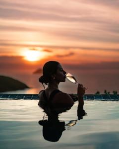 a woman in the water drinking from a bottle at Buzios Mar Hotel in Búzios