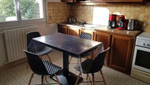 a kitchen with a table and chairs in it at Maison ouvrière pour 8 personnes in Trignac