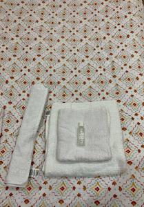 a white towel and a knife on a bed at Studio 1 centre ville RDC in Bar-le-Duc