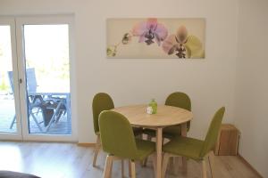 Un comedor con una mesa y sillas verdes. en Ferienwohnung Leidl Beilngries, en Beilngries