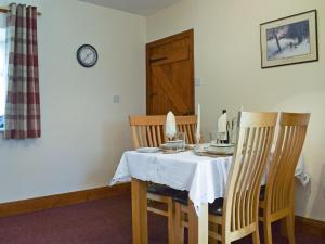 une salle à manger avec une table et deux chaises dans l'établissement Caroch Cottage, à Comrie
