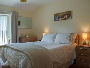 une chambre avec un lit et deux lampes et une fenêtre dans l'établissement Caroch Cottage, à Comrie