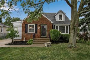 ein Backsteinhaus mit einem Baum im Hof in der Unterkunft Family Home King Beds EV Charger WFH AC in Buffalo