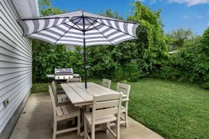 ein Tisch und Stühle mit einem Sonnenschirm auf einer Terrasse in der Unterkunft Family Home King Beds EV Charger WFH AC in Buffalo