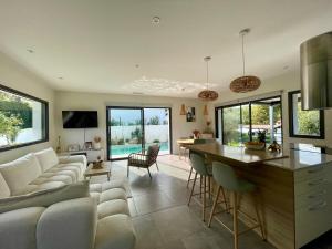 a kitchen and living room with a couch and a table at Maison individuelle contemporaine avec piscine in Urrugne