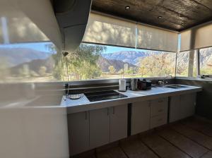 a kitchen with a large window with a mountain view at Red Hill Lodge Purmamarca in Purmamarca