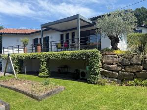 a house with a garden and a stone wall at Maison individuelle contemporaine avec piscine in Urrugne