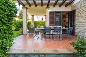 a patio with a table and chairs on it at Villa Federica by MMega in Forte dei Marmi