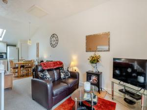 a living room with a leather couch and a television at Wanderer in Sutton