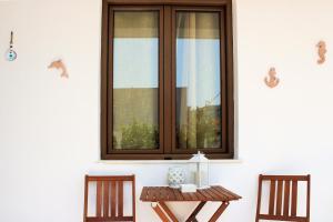 a table and two chairs in front of a window at Péra Skopelos - Mesa Sta Skalia in Skopelos Town