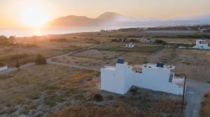 an aerial view of a white building with the sunset in the background at Mediterranean Blue Suites & Villa - Blue Horizon Suite in Tympáki