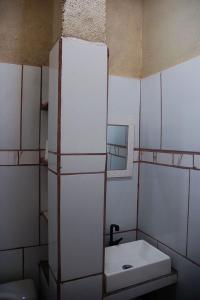 a white bathroom with a sink and a mirror at Pousada Manua in Manaus +26 photos