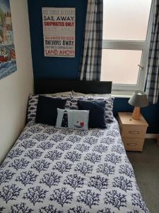 a bedroom with a bed with a blue and white comforter at Rowntree Seaview Holiday Flats small double room with no view in Bridlington