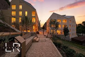 a city street with benches and buildings at sunset at Castle-side Luxury Residence on Danube River bank,Free Parking in Bratislava