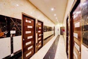 a hallway with wooden doors in a building at Hotel O Blue Vibes in Meerut
