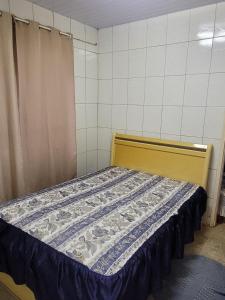 a bedroom with a bed with a blue and white quilt at Recanto felicidade casa de vovó in Monte Sião