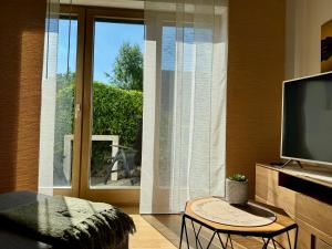a living room with a flat screen tv and a window at Heimatliebe in Neunkirchen