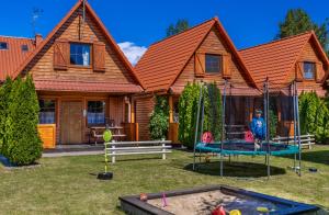 a house with a playground in front of it at Mandala Domki in Bobolin