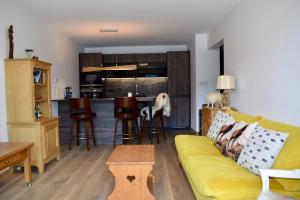 a living room with a yellow couch and a kitchen at Morzine T2 vue imprenable in Morzine
