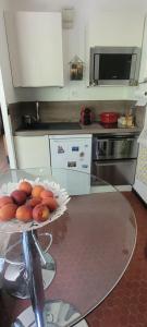 Grand studio près Lac Gaillands في شامونيه مون بلان: مطبخ مع طاولة زجاجية مع صحن فاكهة