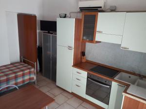 a kitchen with white cabinets and a stainless steel refrigerator at Bibbona Summer - Pineta 1 - in Marina di Bibbona +23 photos