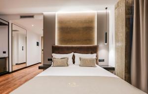 una camera da letto con un grande letto bianco con due cuscini di Cuni Luxury Hotel a Sarandë