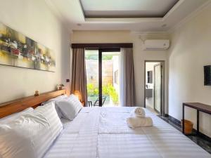 a large white bed in a room with a window at Villa Araya in Nusa Dua +14 photos