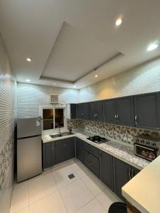 a large kitchen with gray cabinets and a sink at شاليه اليجانس in Jeddah +4 photos