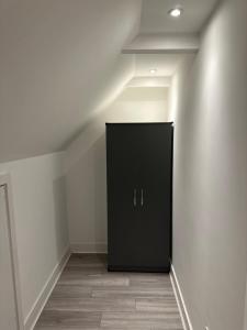 a black cabinet in the corner of a room at Epsom High Street Apartment 10 in Epsom