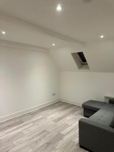 a living room with white walls and a couch at Epsom High Street Apartment 10 in Epsom