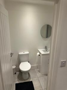 a white bathroom with a toilet and a sink at Epsom High Street Apartment 10 in Epsom