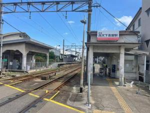 a train station with a sign on the tracks at Nippori Osaka Nishi-Tengachaya Guesthouse西天下茶屋アパートメント in Osaka