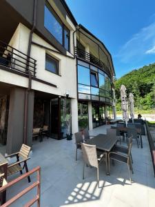 a patio with a table and chairs in front of a building at Vila Premiere Bistro-Spa in Piatra Neamţ
