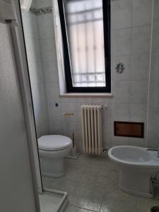 a bathroom with a toilet and a sink and a window at Appartamento a Ponente in Massafra +2 photos