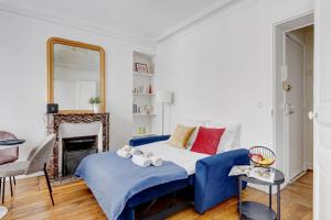 Un dormitorio con una cama azul y un espejo. en Suite Chapu - Cocon au cœur du 16e arrondissement, en París