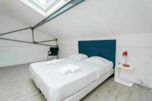 a bedroom with a large white bed and a desk at Artist Loft Experience Stylish 4-Bedroom Stay in Montreuil